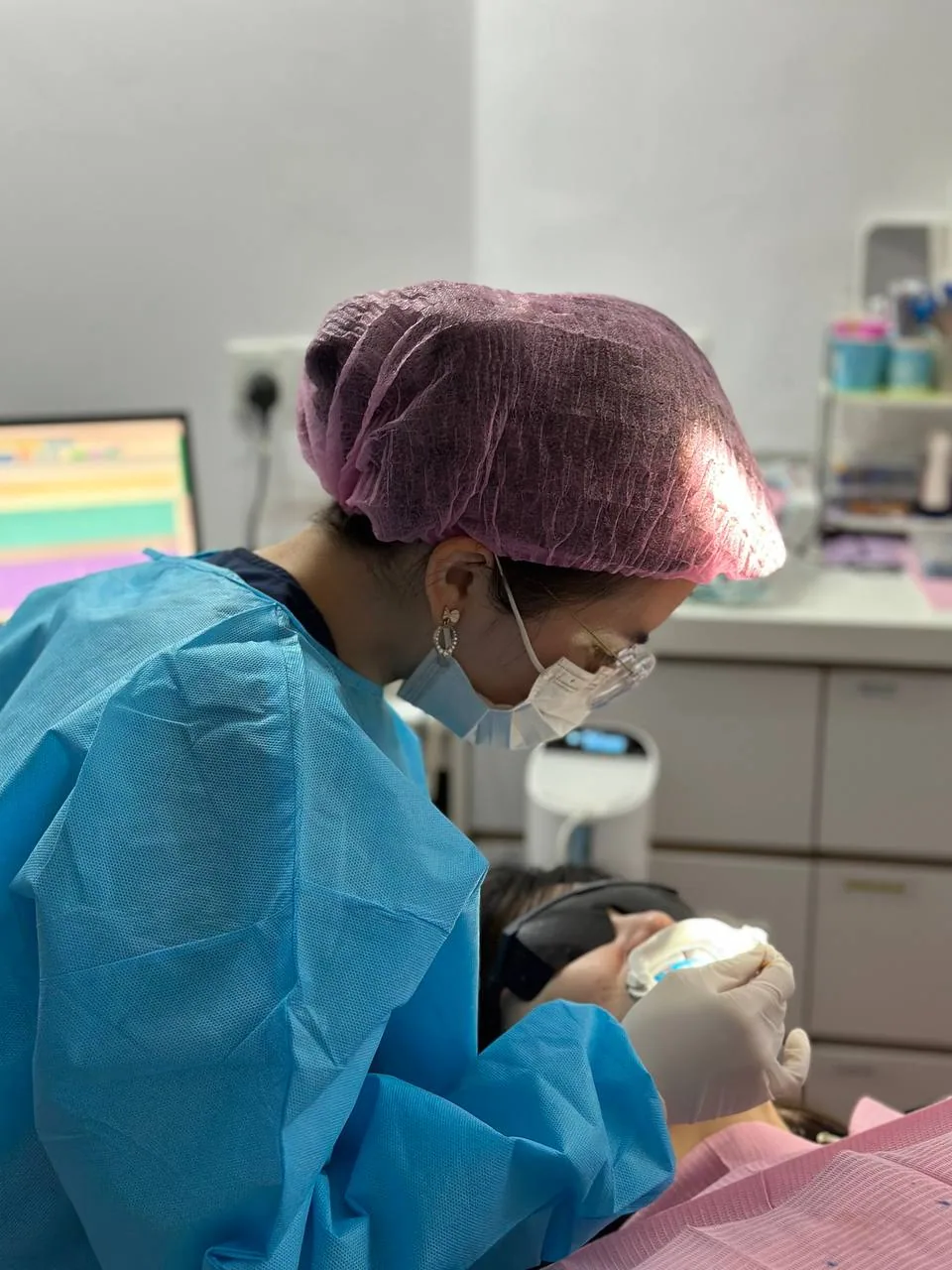 Clinician carrying out a cosmetic dental procedure to improve the shape and colour of a patient's front teeth for a natural-looking smile
