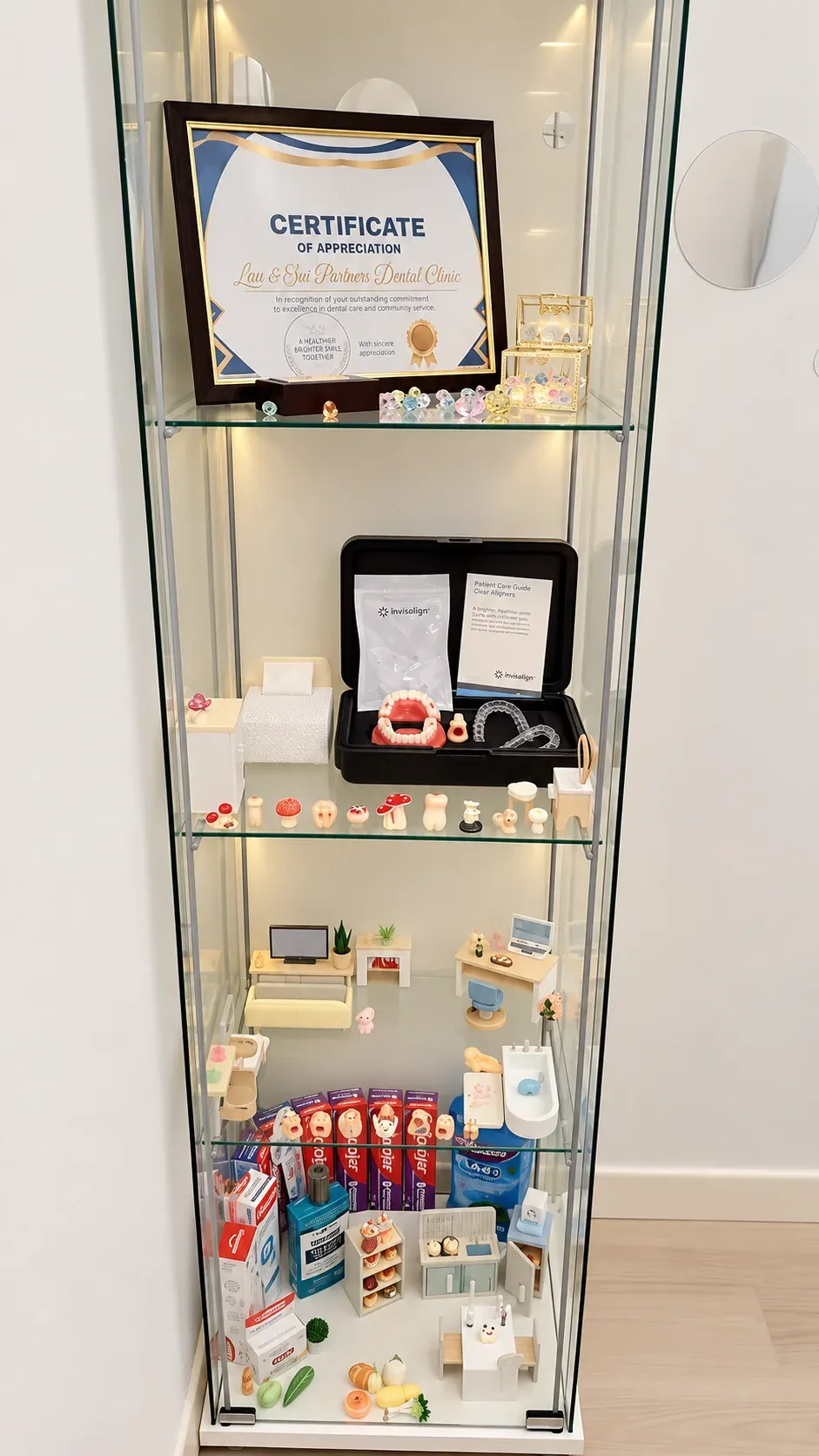 Glass display cabinet of oral care products, dental models and a certificate of appreciation in the reception of our Bukit Jalil clinic