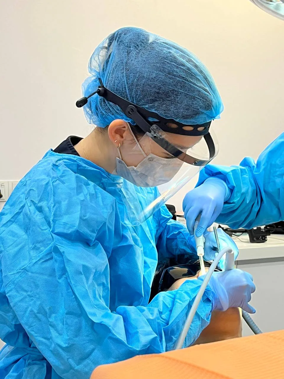 Dentist preparing a tooth for a crown restoration at our Bukit Jalil clinic, protecting a cracked tooth with a custom-made cap