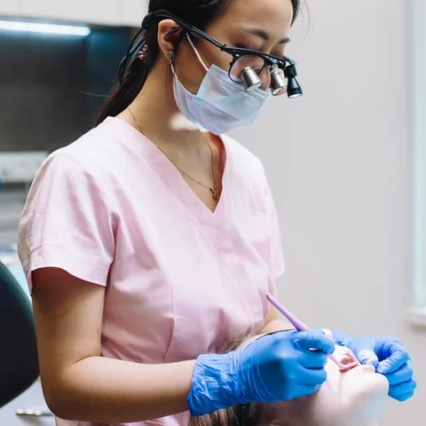 Dentist wearing loupes examining a patient during a routine check-up