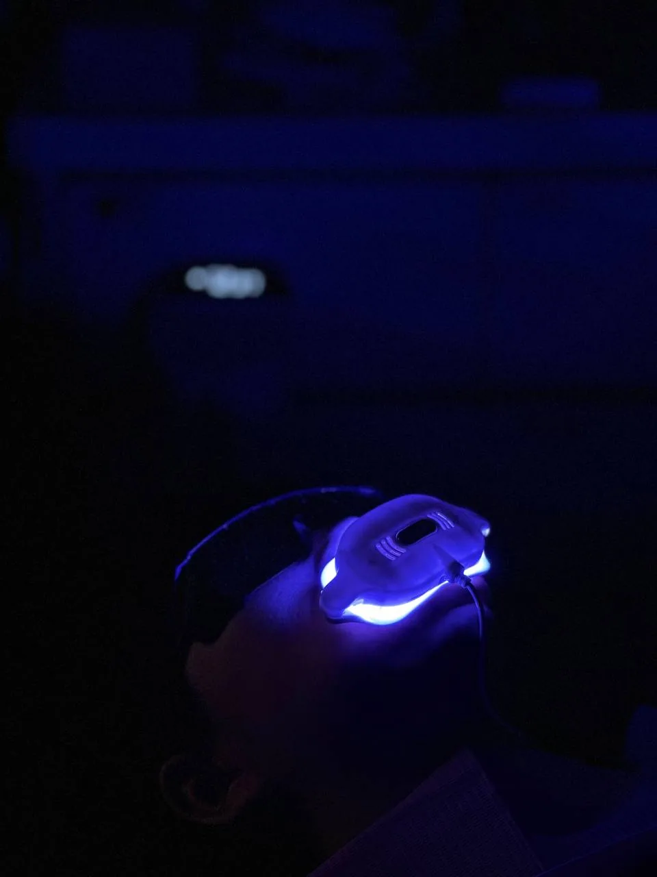 Blue LED activation light over a patient during in-office teeth whitening, speeding up the gel for a brighter smile in one visit