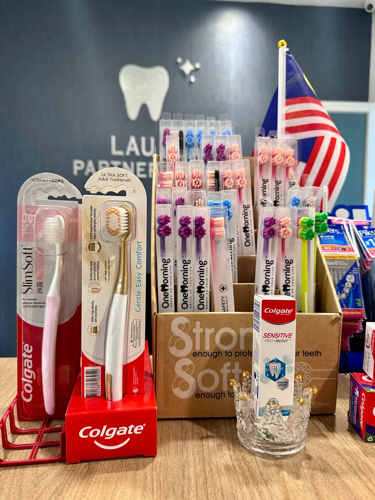 Toothbrushes and toothpaste displayed at the reception counter of our Bukit Jalil dental clinic for patients to take home