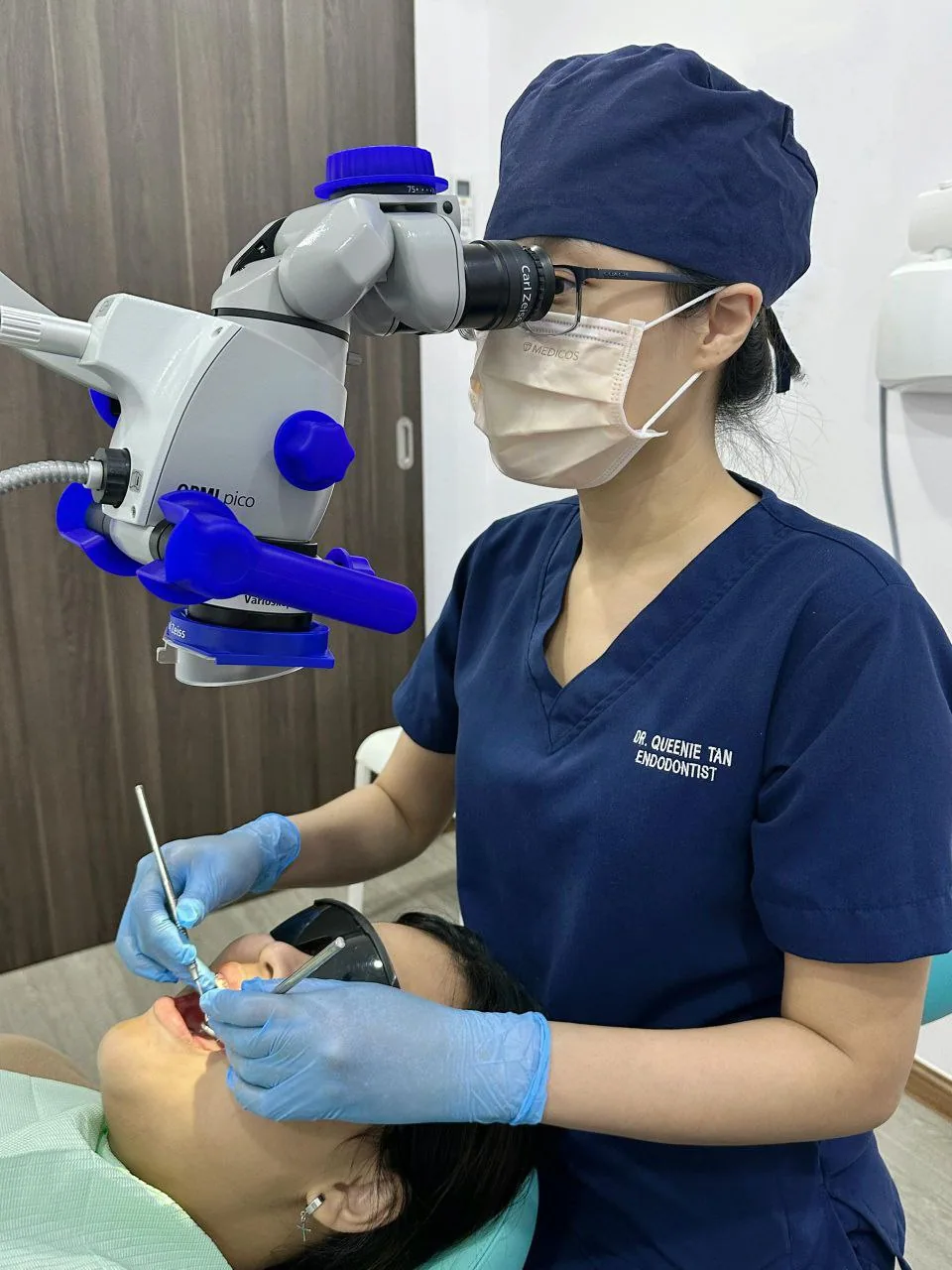Endodontist performing root canal treatment under a dental microscope to save an infected tooth and relieve pain